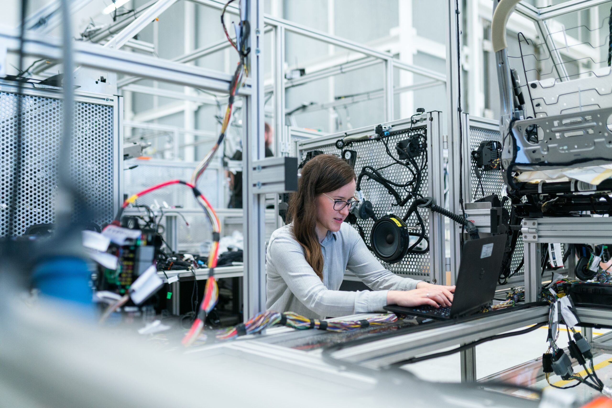 Lady at computer in manufacturing factory with equipment around her