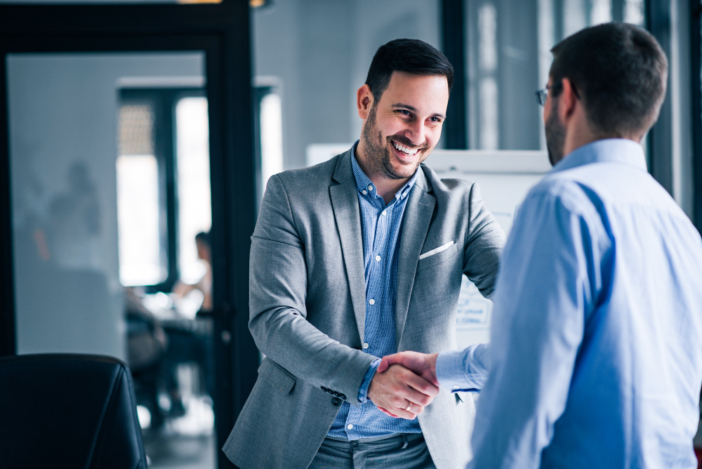 Two men shaking hands and smiling