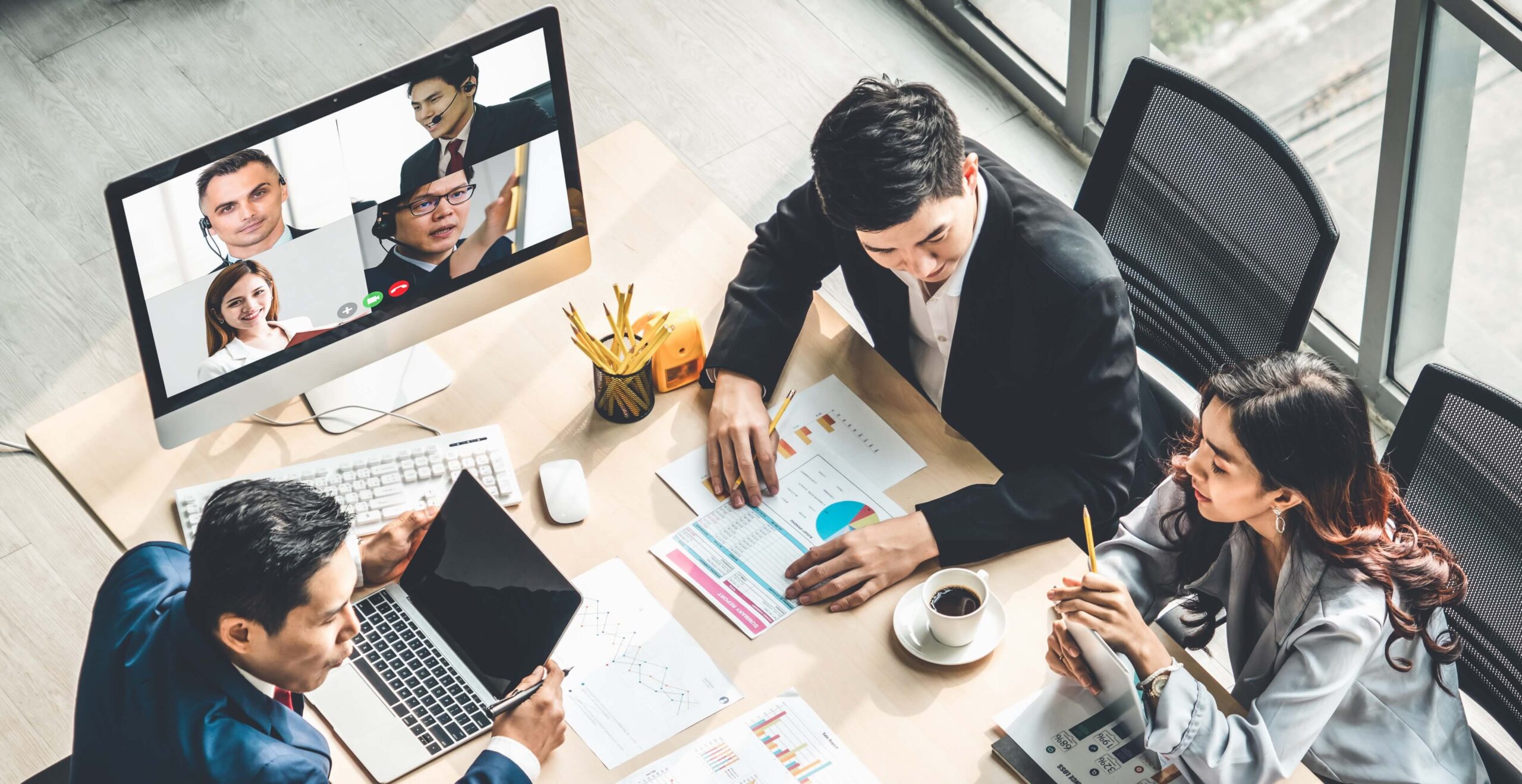 Business meeting with people on video call on a screen