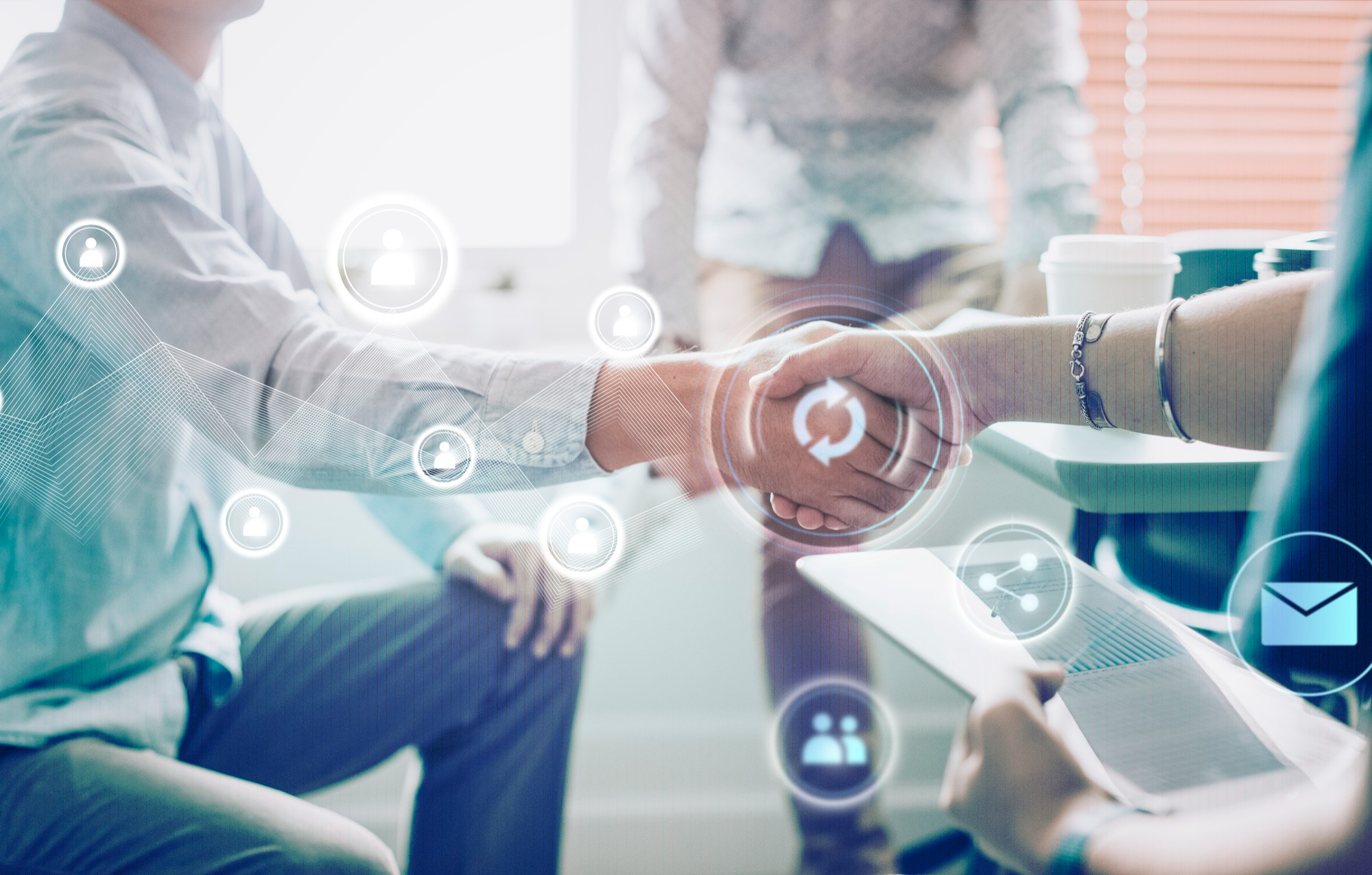 Two people shaking hands with digital icons overlaid