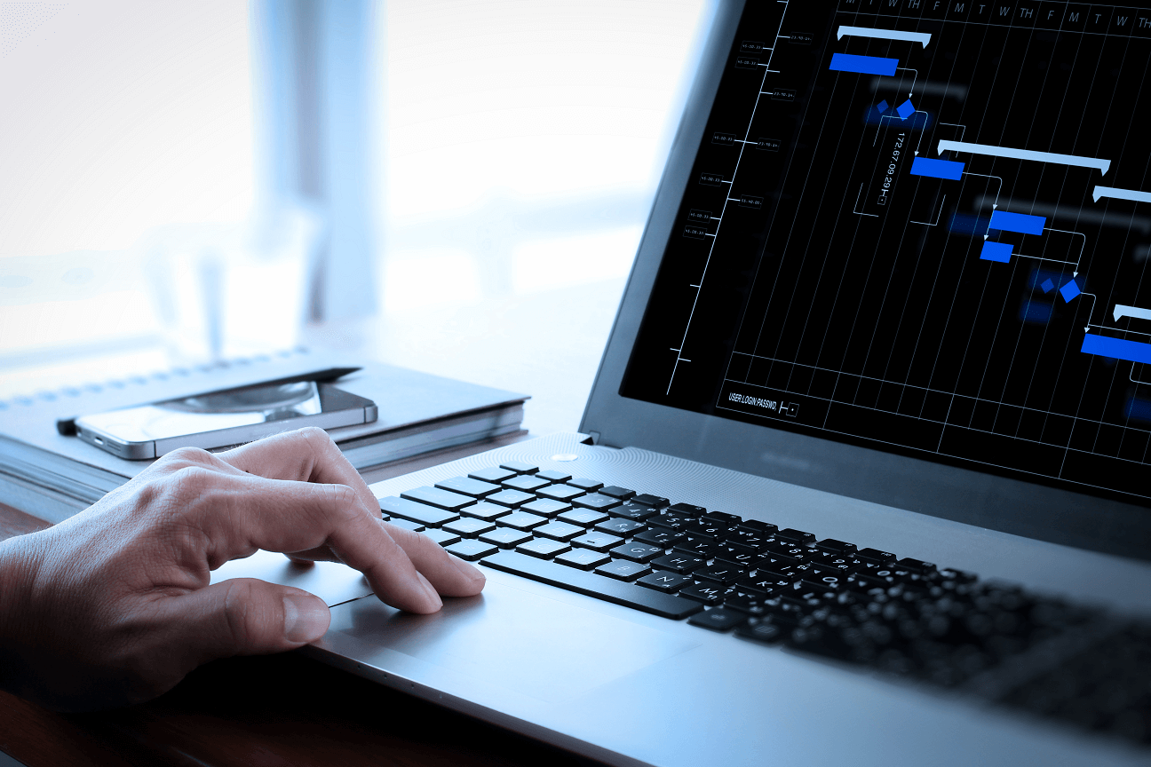 Hand on laptop with Gantt chart on screen